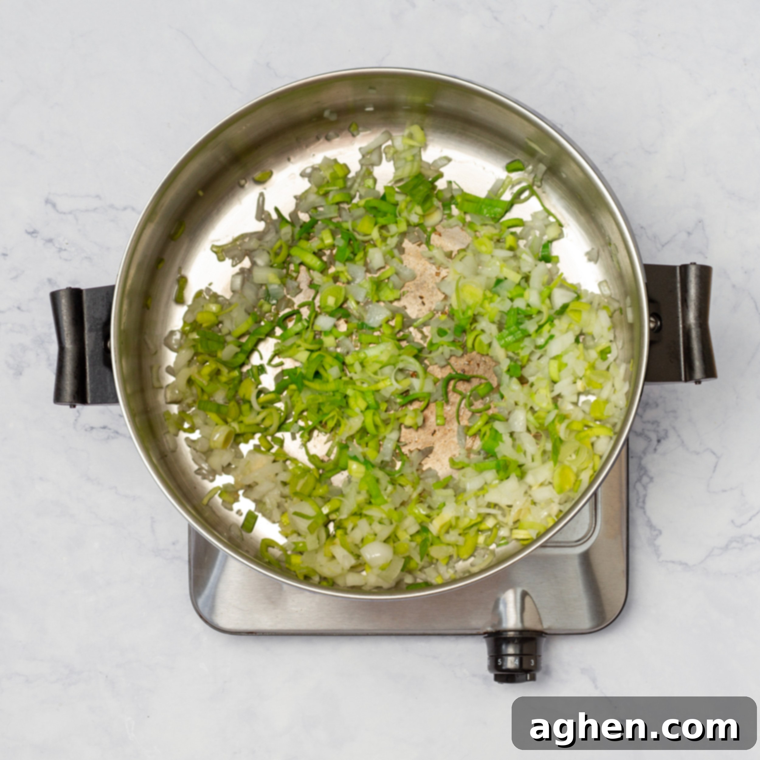 Aromatics (onions, garlic, leeks) sauteing in a soup pot, building flavor for the soup.