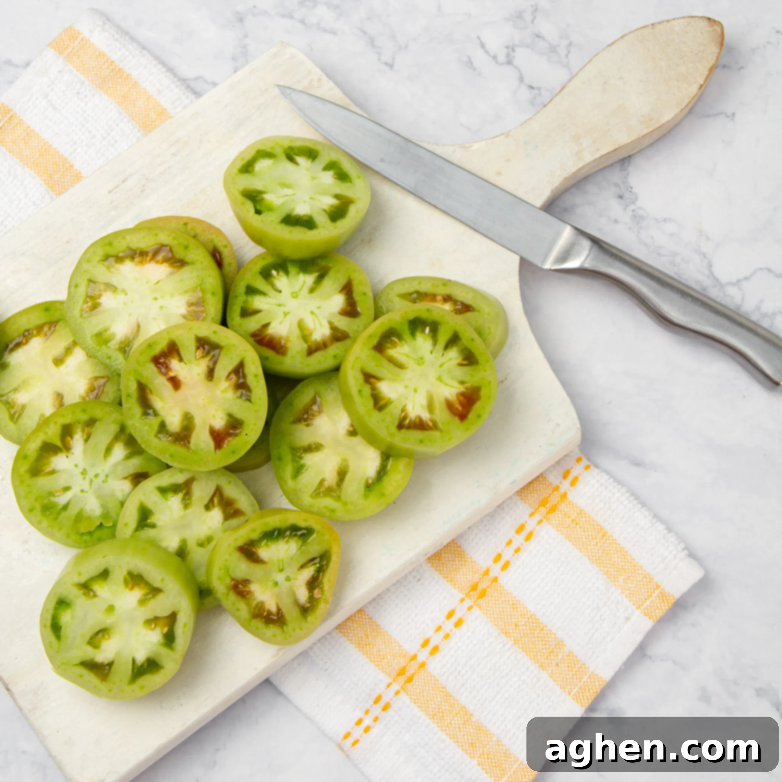 Golden Crispy Air-Fried Green Tomatoes 4 Thick slices of green tomatoes on a cutting board.