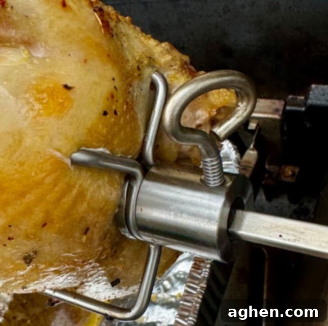 The Only Weber Accessory You Need for Perfectly Tender Chicken 4 A perfectly golden-brown rotisserie chicken carving on a board.