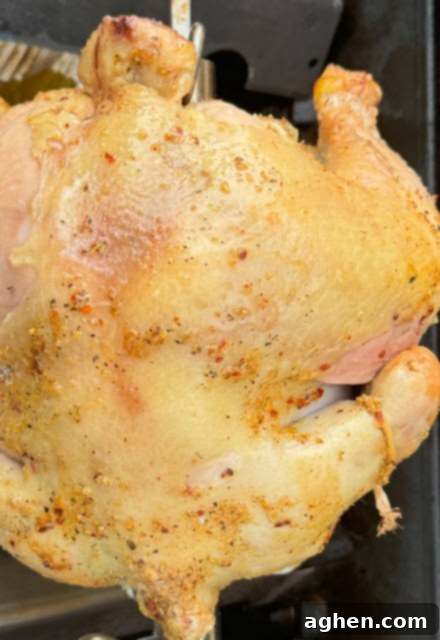 The Only Weber Accessory You Need for Perfectly Tender Chicken 5 A freshly roasted chicken being removed from a rotisserie spit.