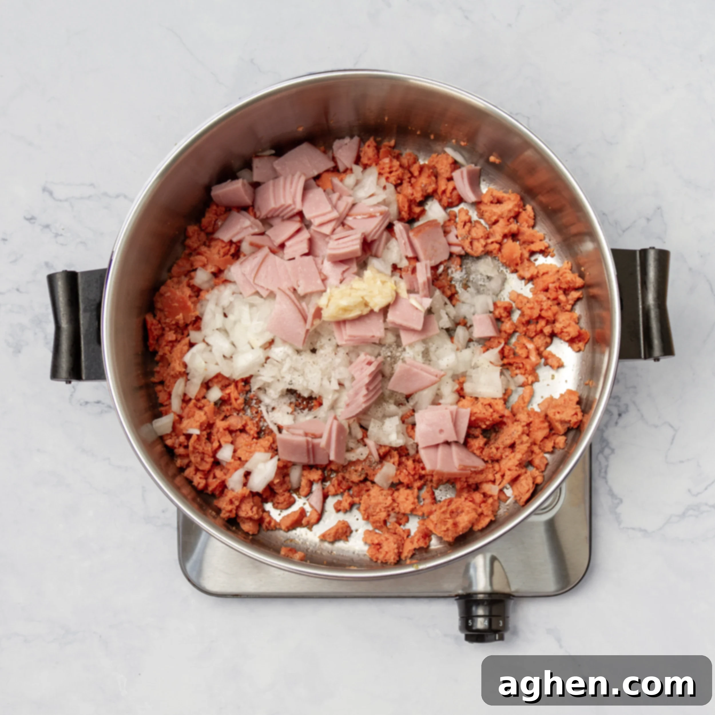 Mastering Olive Garden's Zuppa Toscana At Home 4 Aromatics and meat sauteing in a hot pot.