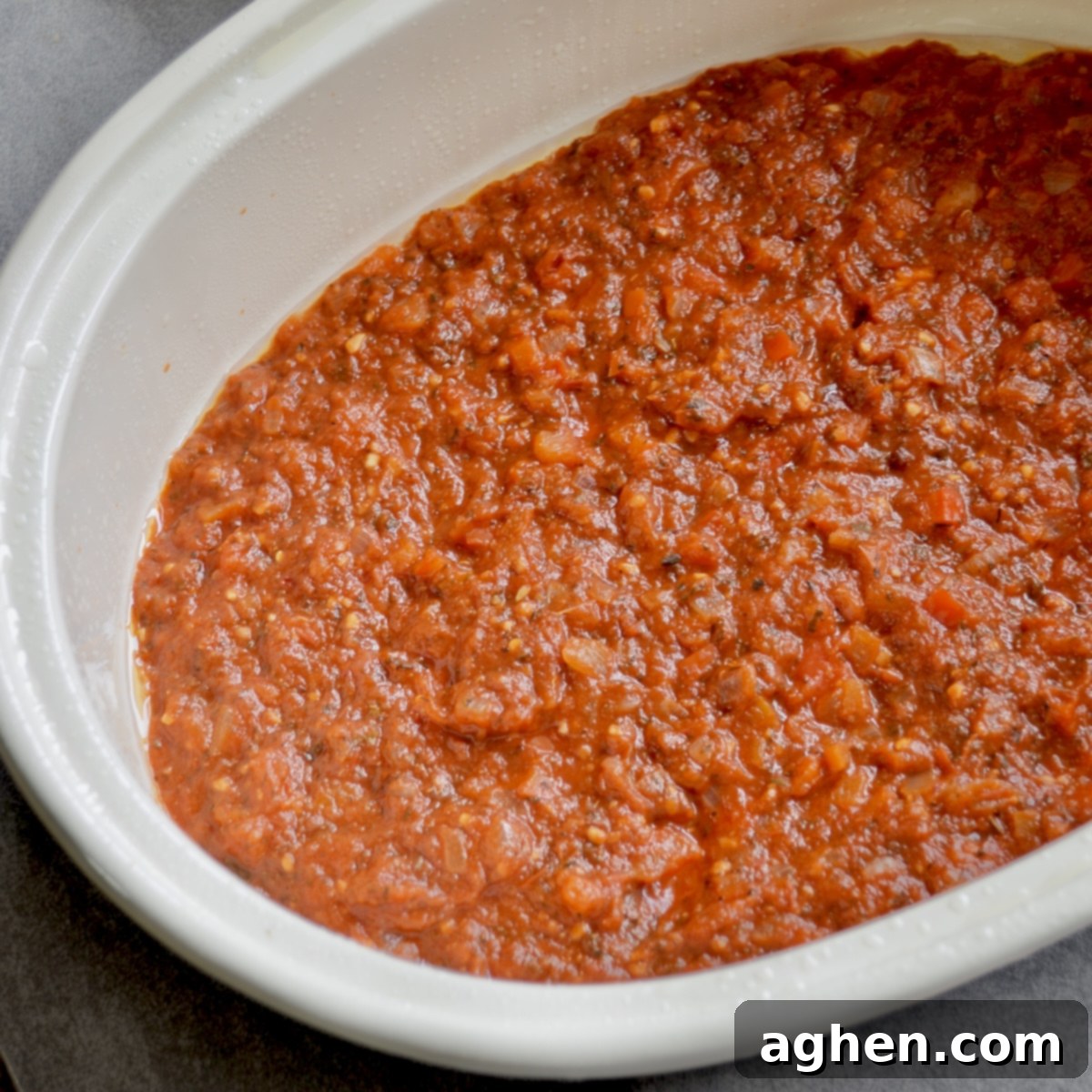 Late Summer Light Ratatouille Bake 5 Tomato sauce spread in the bottom of a casserole dish.
