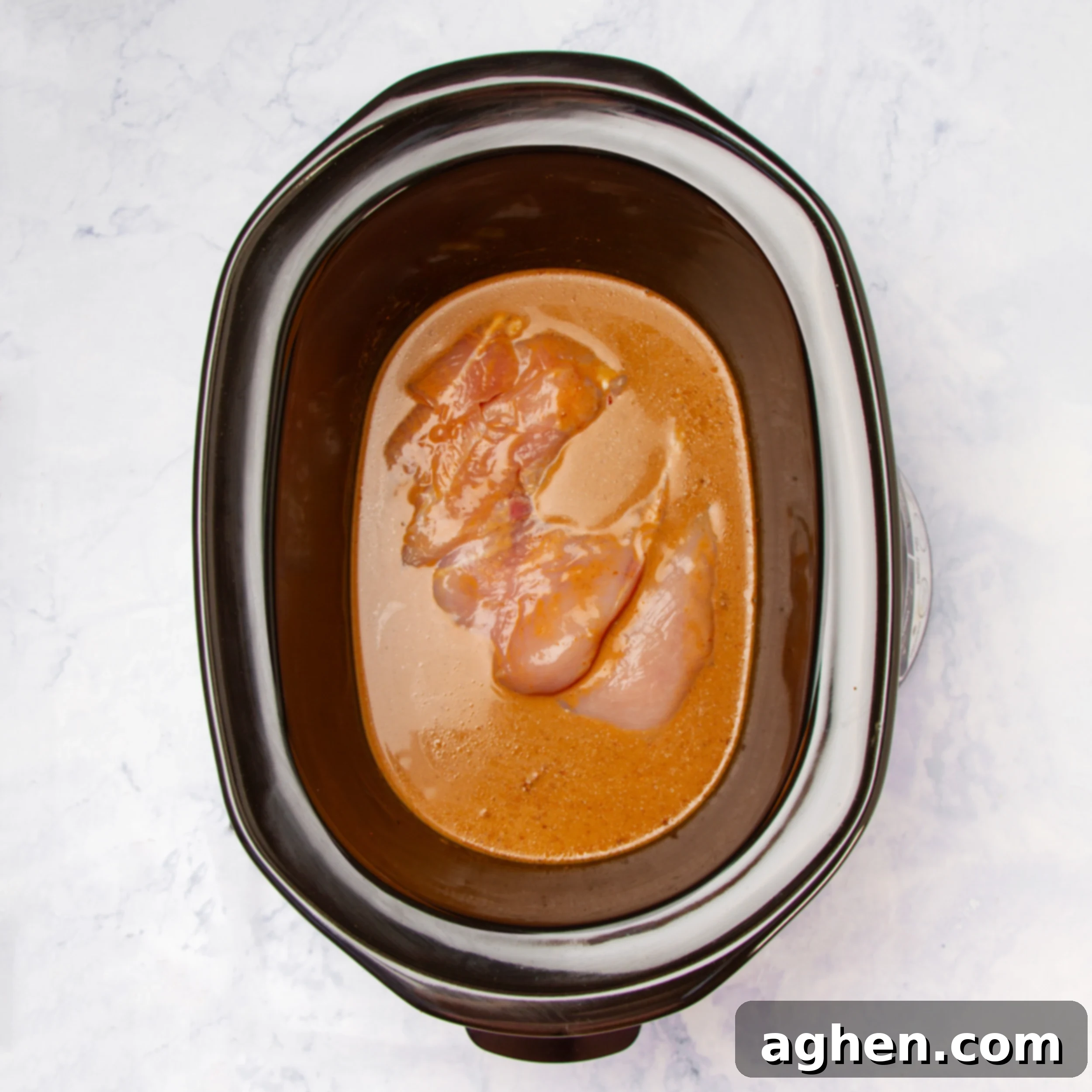 Comforting Slow Cooker Chicken Pumpkin Curry 4 Raw chicken marinating in curry sauce in the Instant Pot liner, ready for slow cooking.