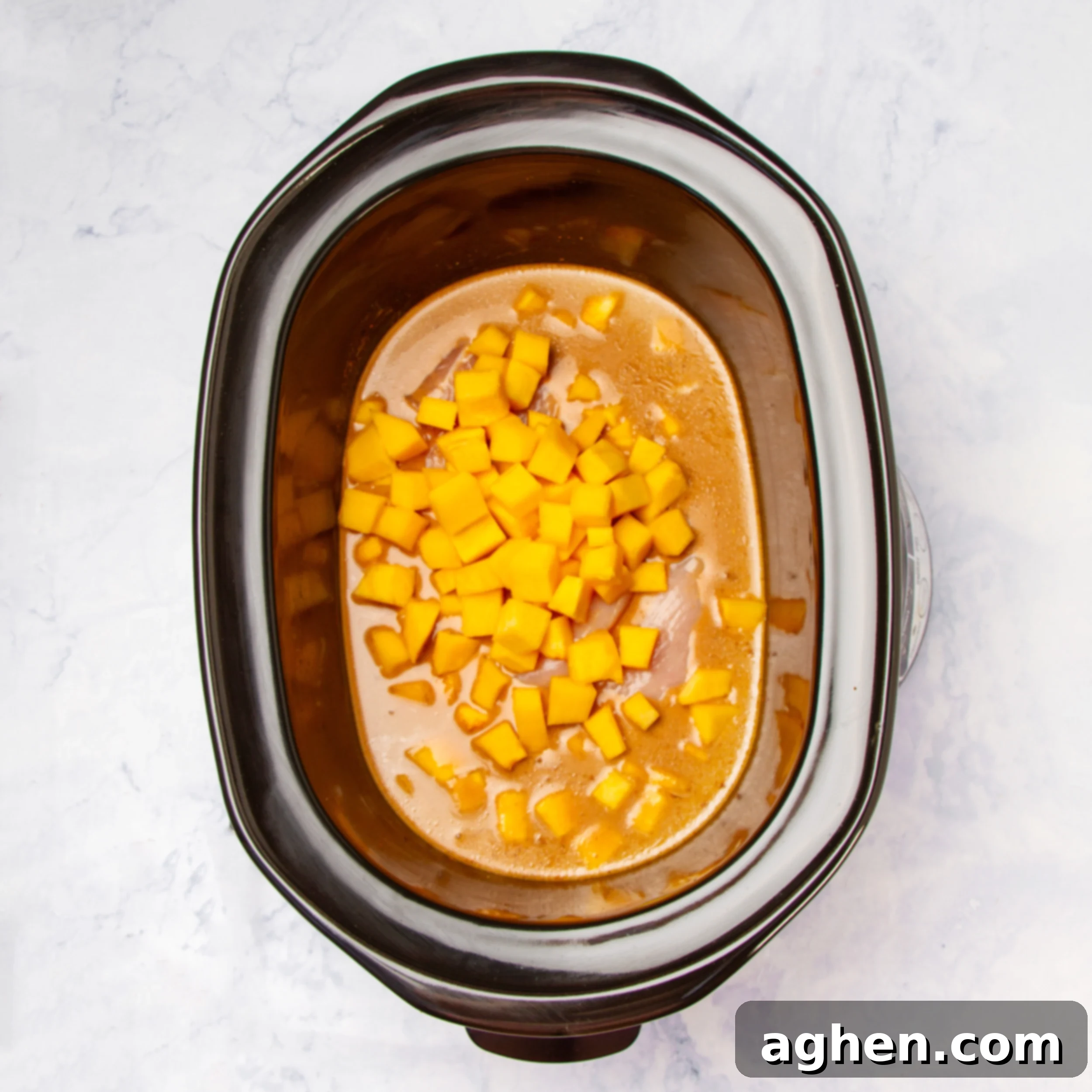 Comforting Slow Cooker Chicken Pumpkin Curry 5 Raw chicken, rich curry sauce, and pumpkin cubes combined in the Instant Pot, before cooking.