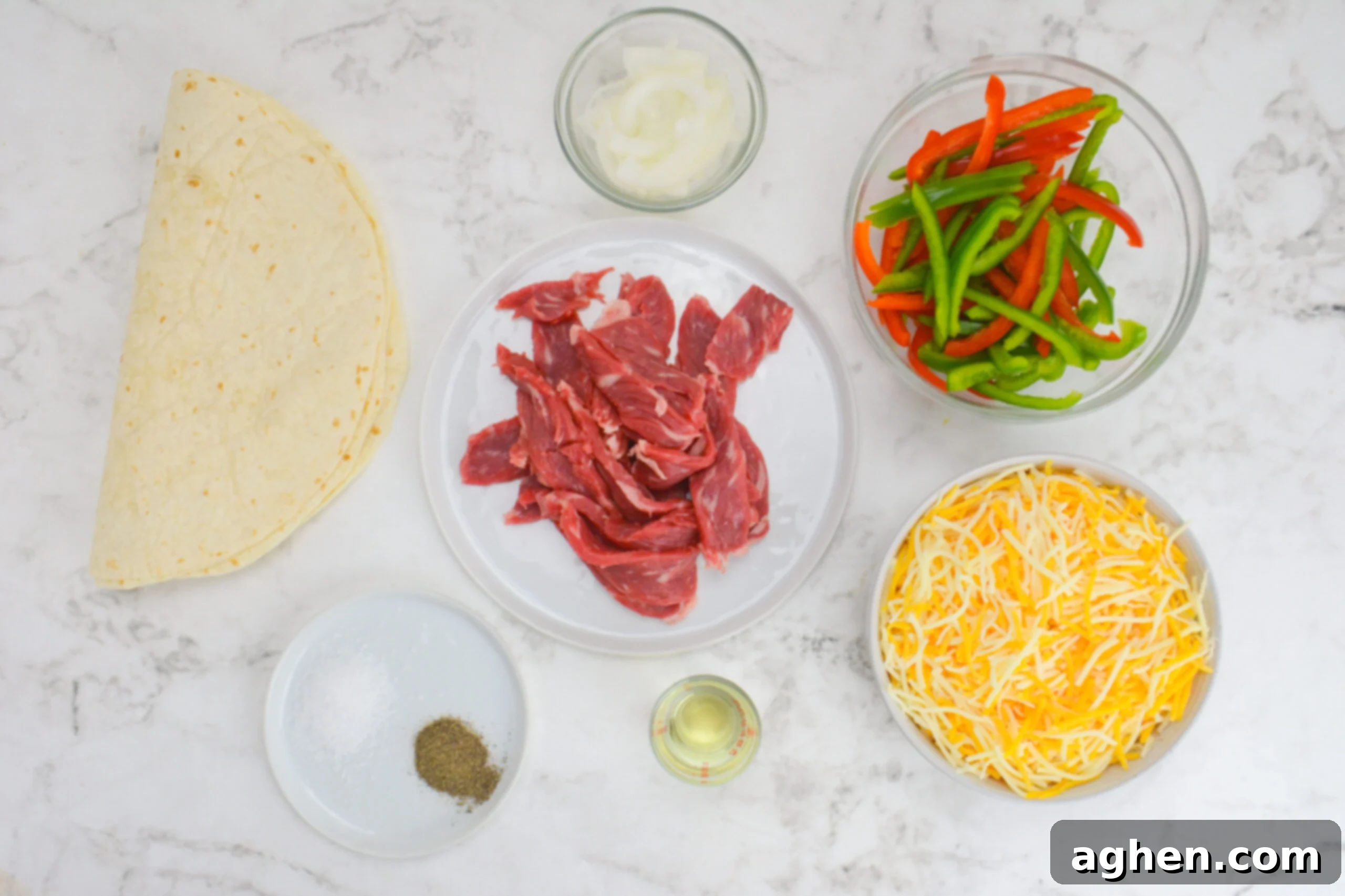 Blackstone Steak Quesadillas So Good They're Eaten Off the Griddle 3 raw ingredients for blackstone steak quesadillas spaced out on a white surface in separate bowls and plates.