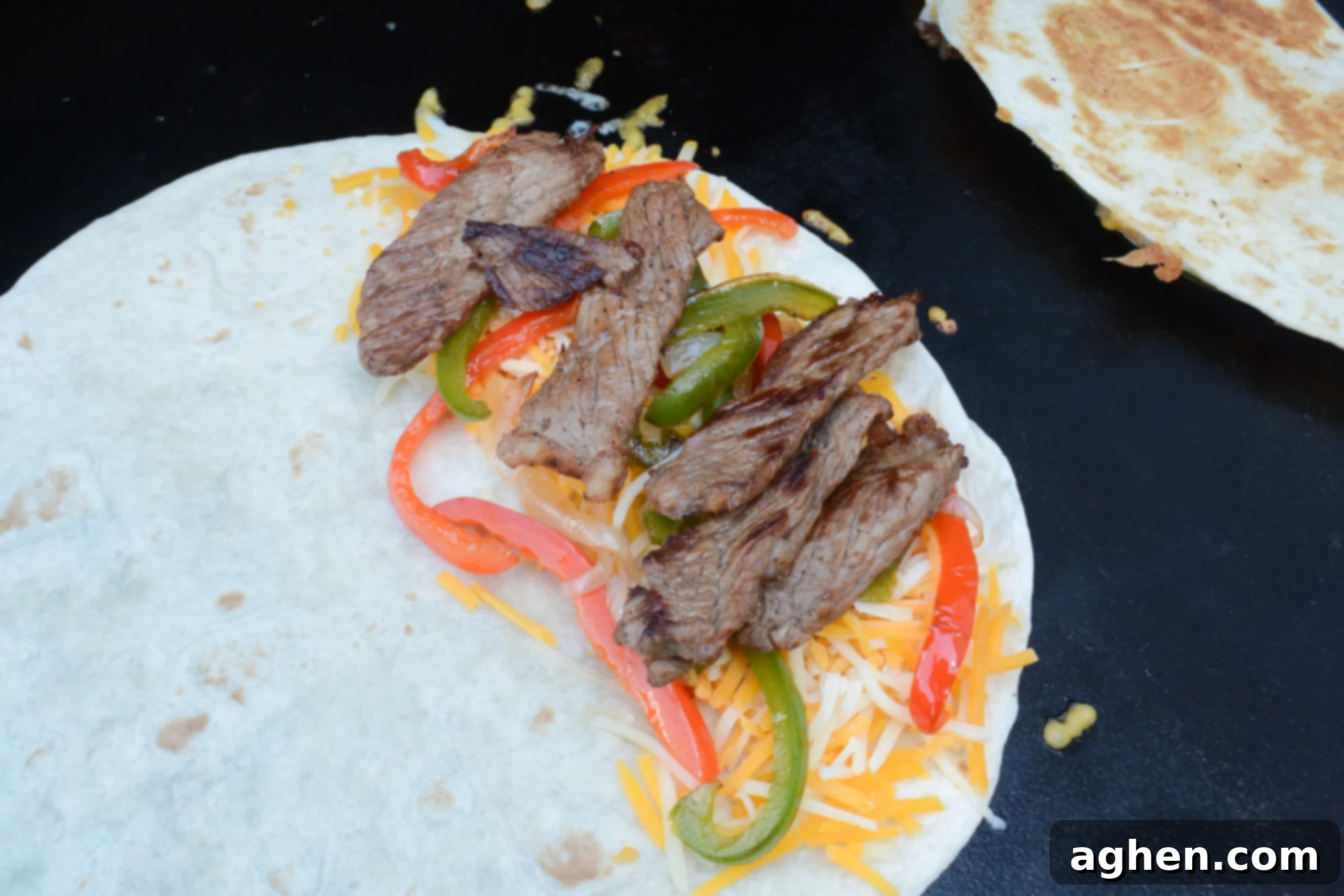 Blackstone Steak Quesadillas So Good They're Eaten Off the Griddle 8 steak quesadilla being constructed on the blackstone.