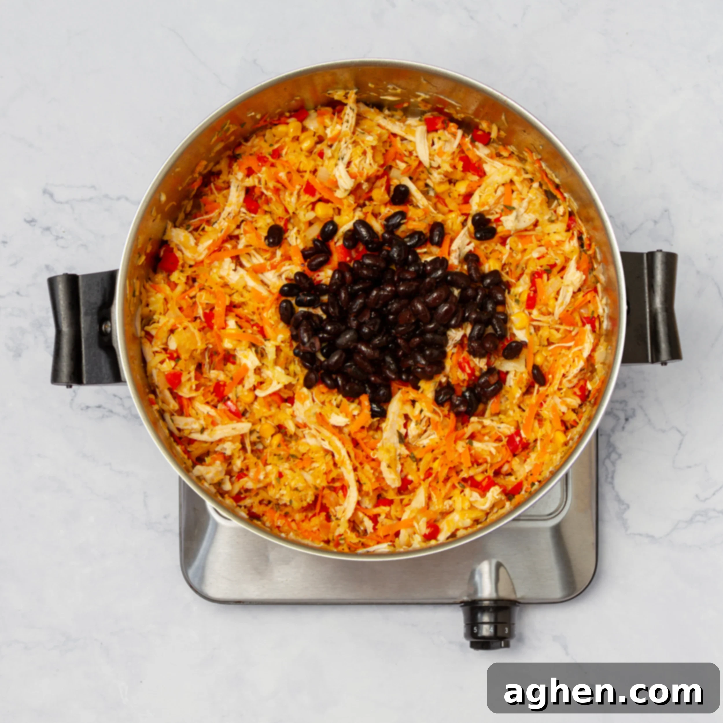 Diyet Dostu Güneybatı Egg Roll Kasesi 7 Black beans being added to the rest of the cooked ingredients in the pan, prior to final stir.