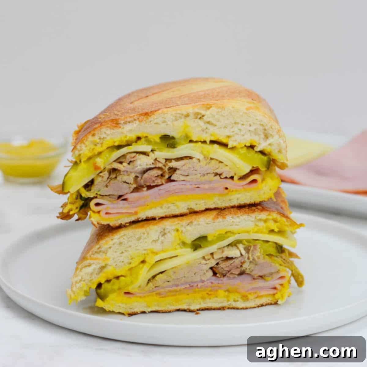 Your 2025 Blackstone Bucket List: 10 Must-Cook Griddle Classics 11 Two halves of Blackstone Cuban Sandwich stacked on top of each other on a white plate.