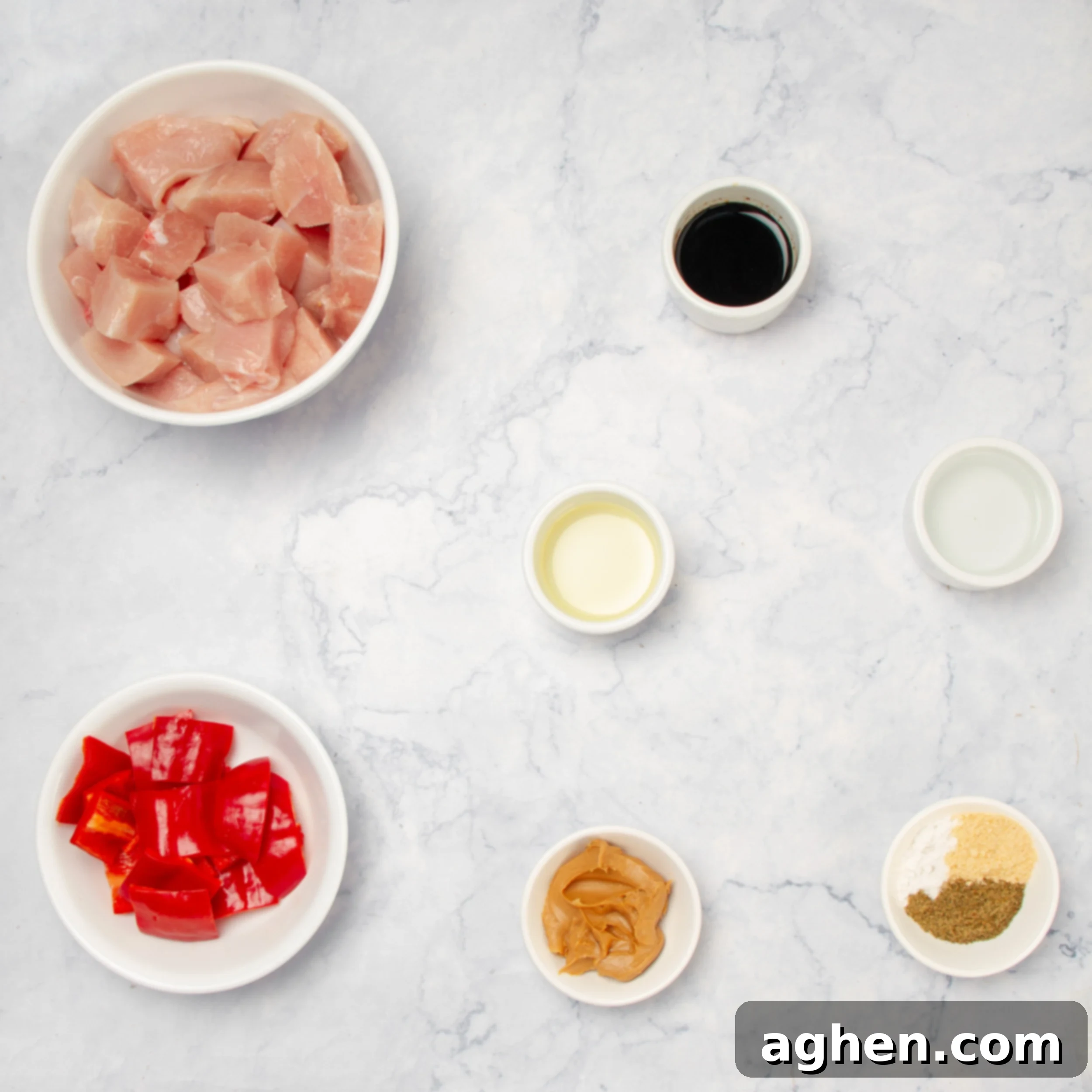 Flavorful Chicken Satay Skewers 3 Ingredients for Chicken Satay Skewers laid out in separate dishes on a clean countertop, ready for preparation.