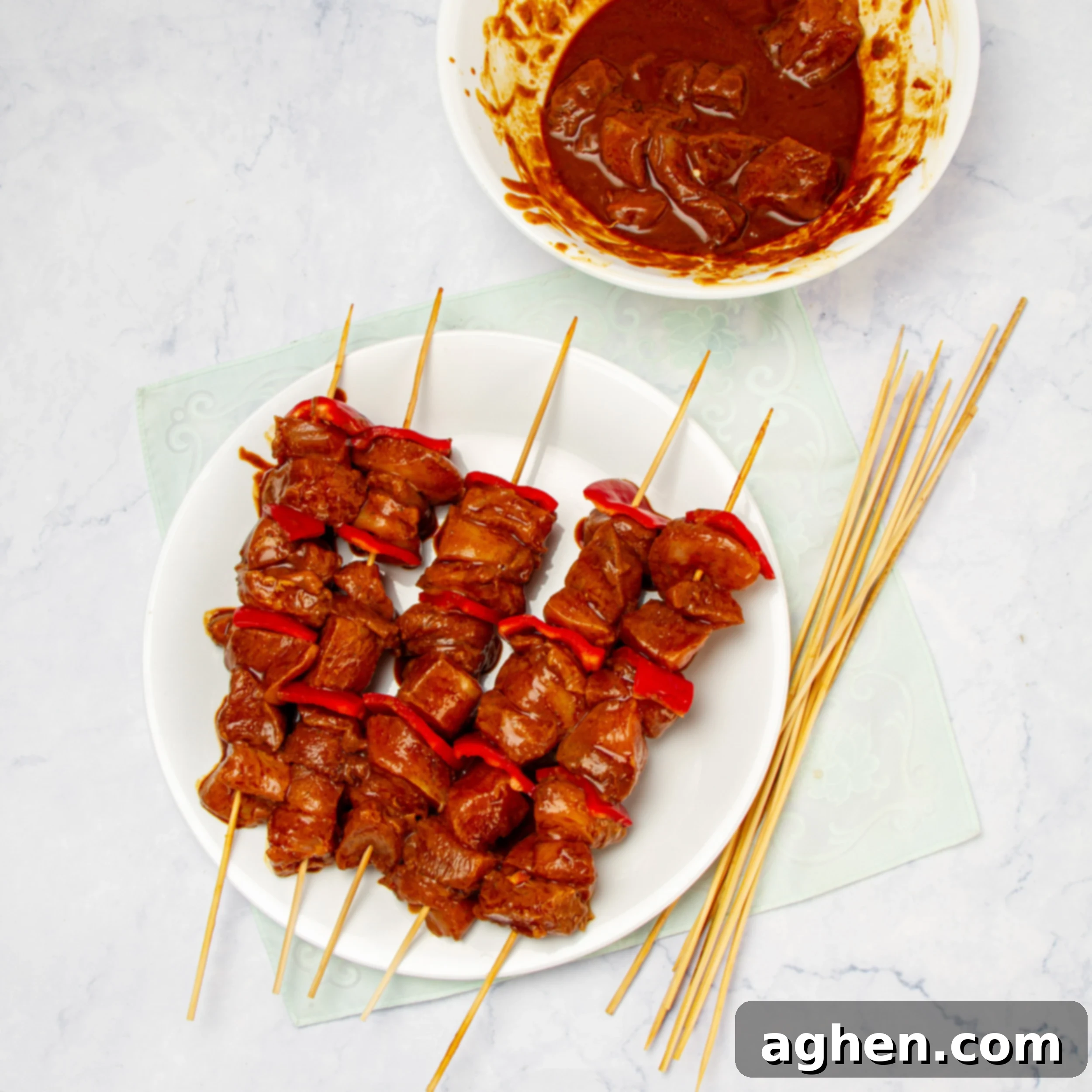 Flavorful Chicken Satay Skewers 5 Threading the marinated chicken and vibrant red bell peppers onto wooden skewers.