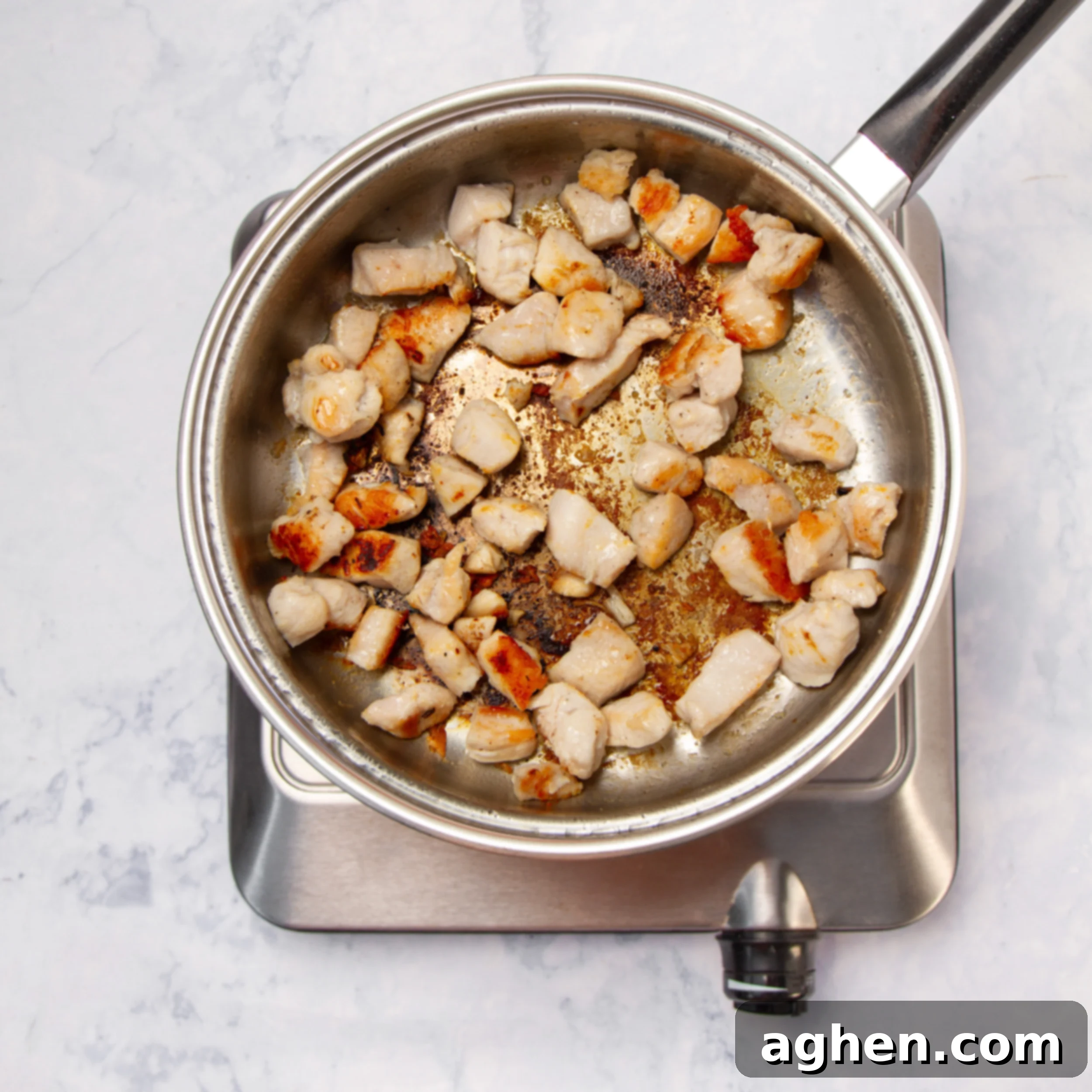 Weight Watchers' Iconic Chicken Caesar Pasta Salad 4 Seasoned chicken cubes cooking in a pan.