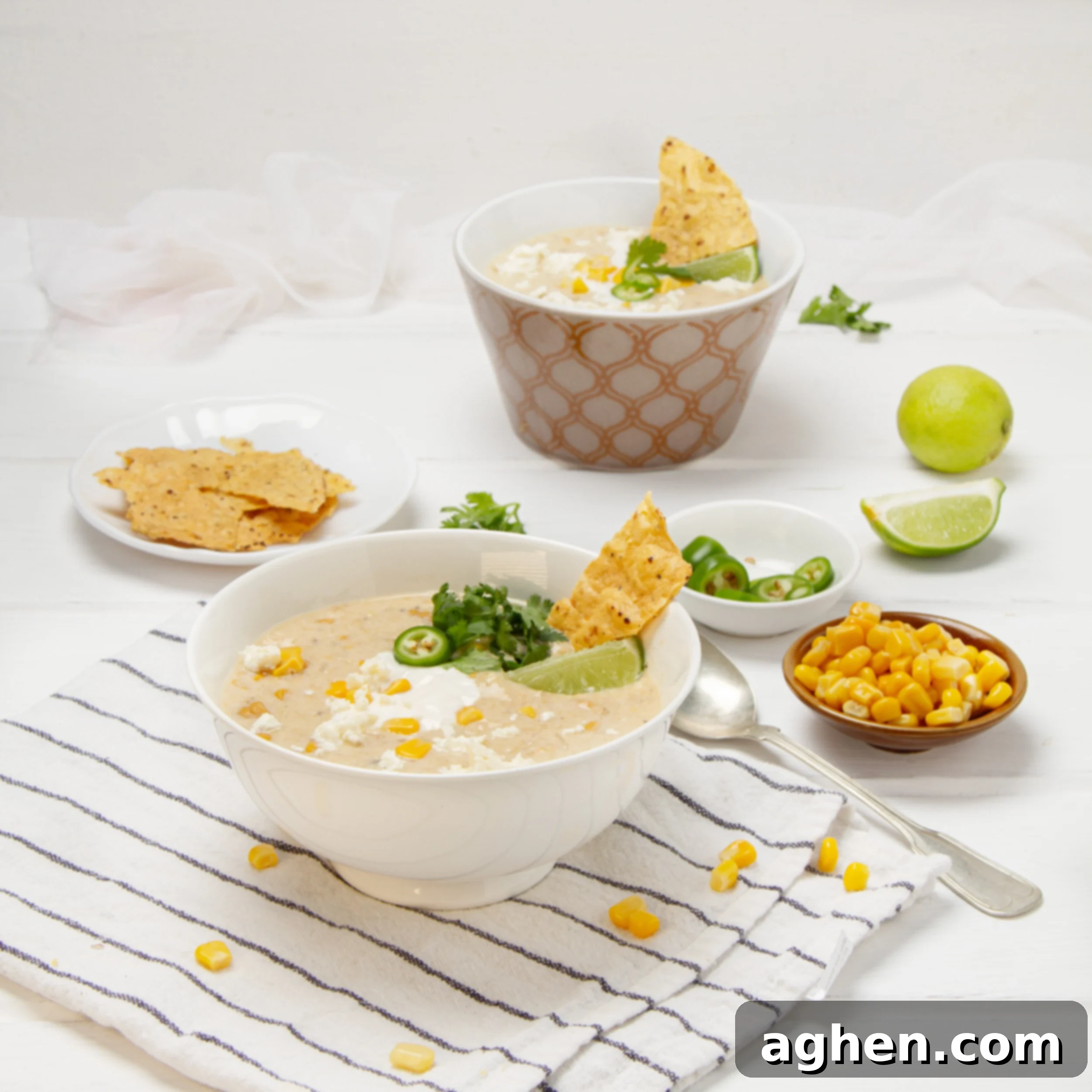 Zesty Mexican Corn Chowder 2 Creamy, authentic Mexican street corn soup in a bowl with chips, fresh lime wedges, and cilantro on the side.