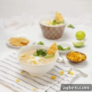 Zesty Mexican Corn Chowder 4 Creamy, authentic Mexican street corn soup in a bowl with chips, fresh lime wedges, and cilantro on the side.