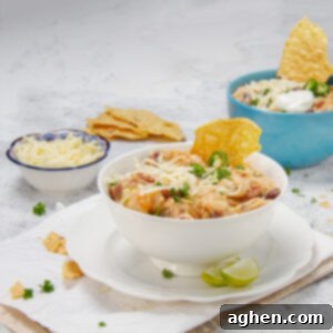 Creamy Cajun Chicken Chili 8 Seriously bold and satisfying Cajun white chicken chili in a bowl with tortilla chips and shredded cheese on the side, ready to be enjoyed.