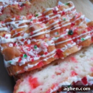 Holiday White Chocolate Peppermint Loaf 2 Close-up of a slice of White Chocolate Candy Cane Loaf, showing the moist texture and candy cane bits.