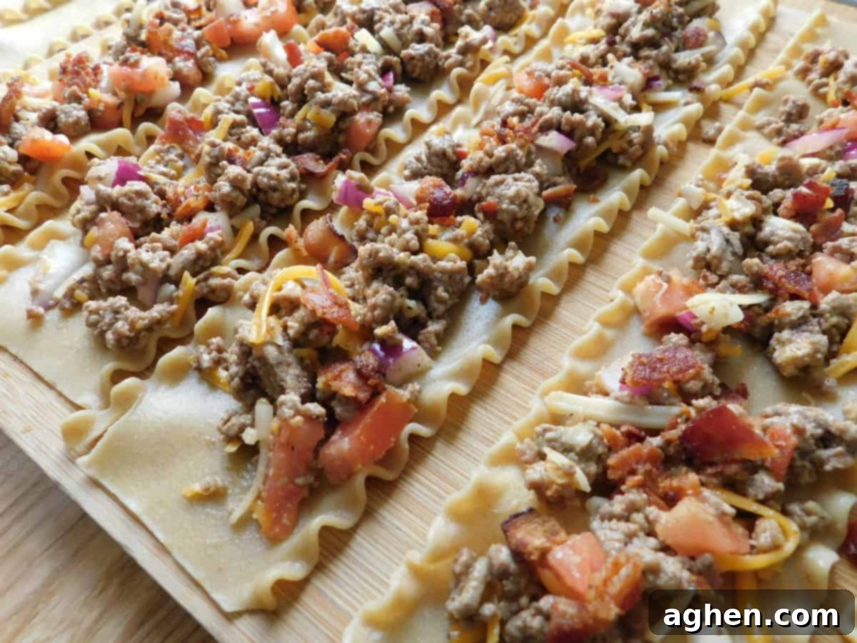 Ultimate Bacon Cheeseburger Lasagna Rolls 5 Spreading meat mixture onto cooked lasagna noodles