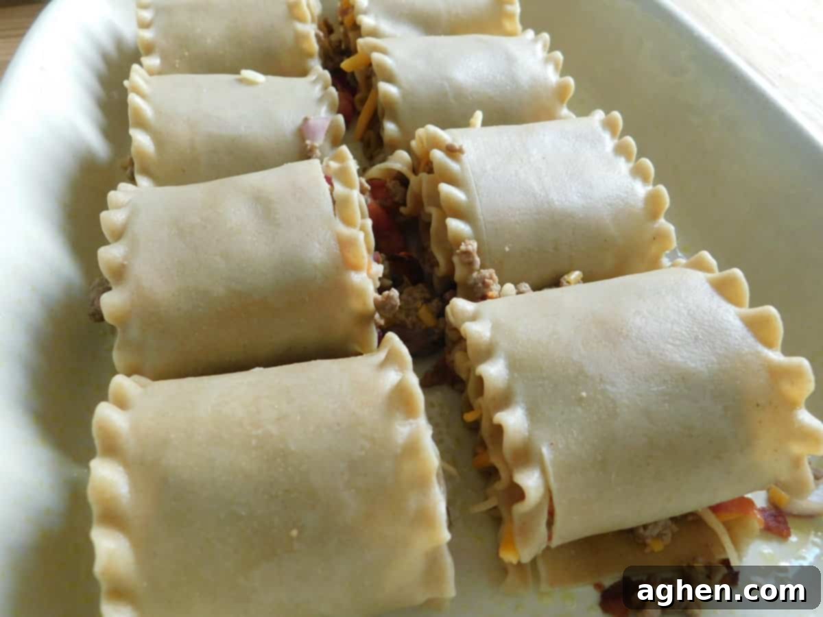 Ultimate Bacon Cheeseburger Lasagna Rolls 6 Finished Bacon Cheeseburger Lasagna Rolls baking in a casserole dish